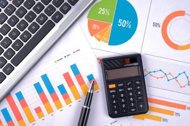 İş grafikleri, grafikleri, istatistikleri ve eğitim ve iş kavramları için arkaplanı olan dizüstü bilgisayar ve kalem