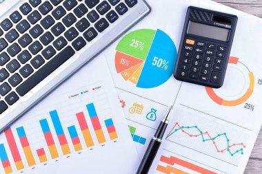 İş grafikleri, grafikleri, istatistikleri ve eğitim ve iş kavramları için arkaplanı olan dizüstü bilgisayar ve kalem