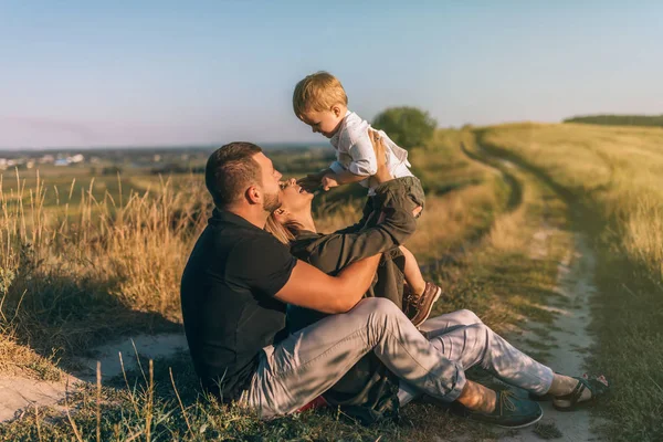 Happy Young Parents Sitting Carrying Adorable Little Son Rural Landscape — Stock Photo, Image