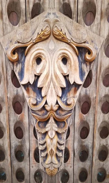 carvings in wood. white wood with gold trim. patina. thread. small depth of field.