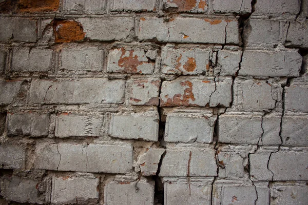 Arka planda çatlaklar olan eski taş duvar