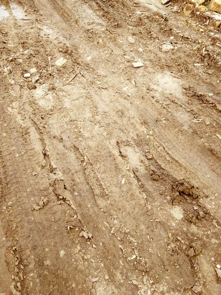 Water paddle on street after falling rain. Way after rain. Dirty puddle on road after rain. Dirt road with muddy puddles, autumn time. Abstract background, texture, pattern, material, wallpaper.