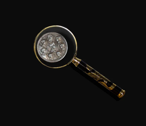 Arka planda büyüteç altında eski para 