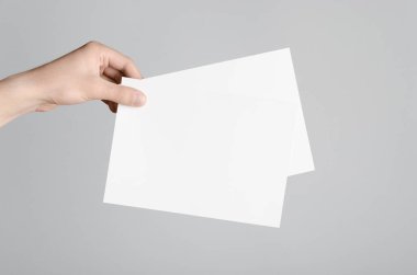 A5 el ilanı / davet Mock-Up - boş el ilanları gri bir arka plan üzerinde tutan eller erkek.