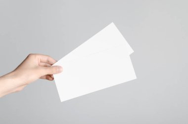 DL el ilanı Mock-Up-erkek elleri boş el ilanları gri bir arka plan üzerinde tutan.