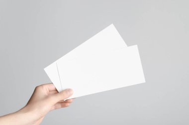 DL el ilanı Mock-Up-erkek elleri boş el ilanları gri bir arka plan üzerinde tutan.