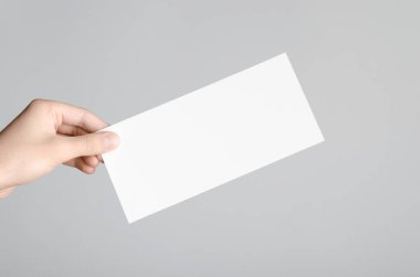 DL el ilanı Mock-Up-gri bir arka plan üzerinde boş bir el ilanı holding erkek eller.