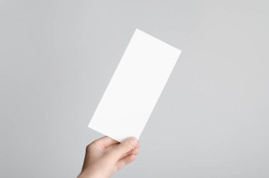 DL el ilanı Mock-Up-gri bir arka plan üzerinde boş bir el ilanı holding erkek eller.