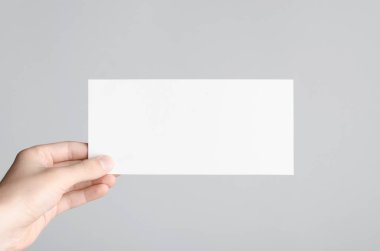 DL el ilanı Mock-Up-gri bir arka plan üzerinde boş bir el ilanı holding erkek eller.