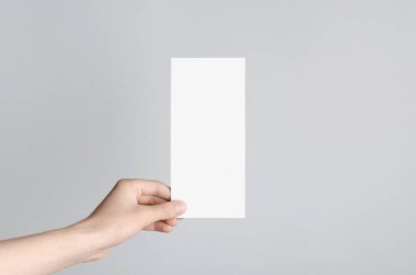 DL el ilanı Mock-Up-gri bir arka plan üzerinde boş bir el ilanı holding erkek eller.