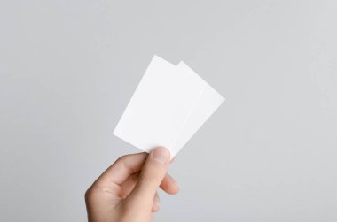 Kartvizit Mock-Up (85x55mm) - erkek gri bir arka plan üzerinde boş kart tutan eller.