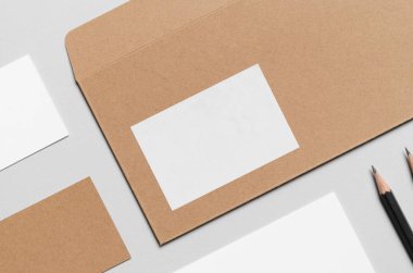 Marka / Kırtasiye Mock-Up-Kraft ve beyaz. Yakın çekim-Dl zarf, övgü kayma (99x210mm), ticari kartlar (85x55mm)
