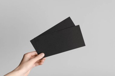 Siyah Dl el ilanı Mock-Up-gri bir arka plan üzerinde siyah flyers holding erkek eller.