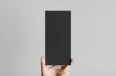 Siyah Dl el ilanı Mock-Up-gri bir arka plan üzerinde siyah bir el ilanı holding erkek eller.