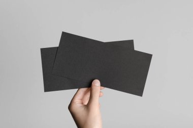 Siyah Dl el ilanı Mock-Up-gri bir arka plan üzerinde siyah flyers holding erkek eller.