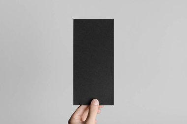 Siyah Dl el ilanı Mock-Up-gri bir arka plan üzerinde siyah bir el ilanı holding erkek eller.