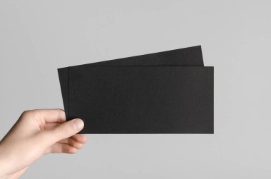 Siyah Dl el ilanı Mock-Up-gri bir arka plan üzerinde siyah flyers holding erkek eller.