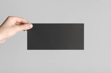 Siyah Dl el ilanı Mock-Up-gri bir arka plan üzerinde siyah bir el ilanı holding erkek eller.