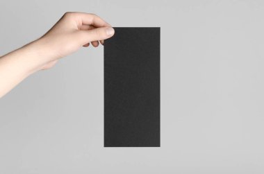 Siyah Dl el ilanı Mock-Up-gri bir arka plan üzerinde siyah bir el ilanı holding erkek eller.