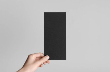 Siyah Dl el ilanı Mock-Up-gri bir arka plan üzerinde siyah bir el ilanı holding erkek eller.