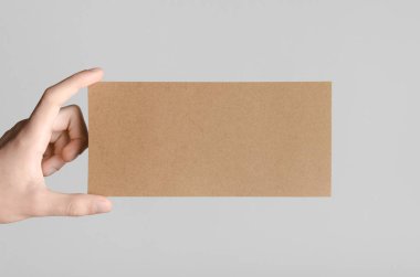 Kraft Dl el ilanı Mock-Up-kraft el ilanı gri bir arka plan üzerinde holding erkek eller.