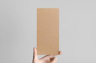 Kraft Dl el ilanı Mock-Up-kraft el ilanı gri bir arka plan üzerinde holding erkek eller.