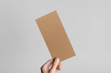 Kraft Dl el ilanı Mock-Up-kraft el ilanı gri bir arka plan üzerinde holding erkek eller.