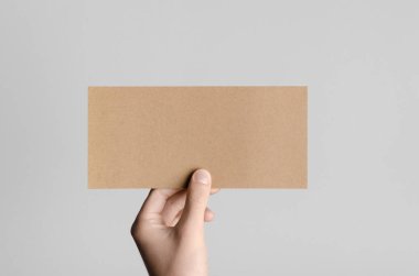 Kraft Dl el ilanı Mock-Up-kraft el ilanı gri bir arka plan üzerinde holding erkek eller.