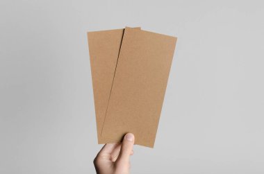 Kraft Dl el ilanı Mock-Up-kraft el ilanları gri bir arka plan üzerinde holding erkek eller.