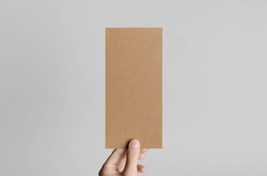 Kraft Dl el ilanı Mock-Up-kraft el ilanı gri bir arka plan üzerinde holding erkek eller.