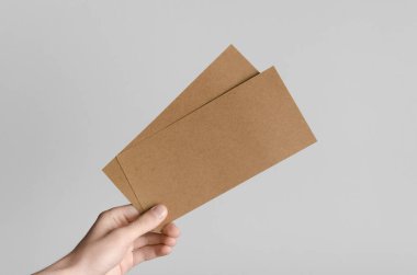 Kraft Dl el ilanı Mock-Up-kraft el ilanları gri bir arka plan üzerinde holding erkek eller.