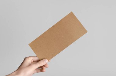 Kraft Dl el ilanı Mock-Up-kraft el ilanı gri bir arka plan üzerinde holding erkek eller.