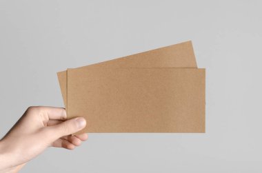 Kraft Dl el ilanı Mock-Up-kraft el ilanları gri bir arka plan üzerinde holding erkek eller.