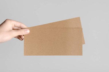 Kraft Dl el ilanı Mock-Up-kraft el ilanları gri bir arka plan üzerinde holding erkek eller.