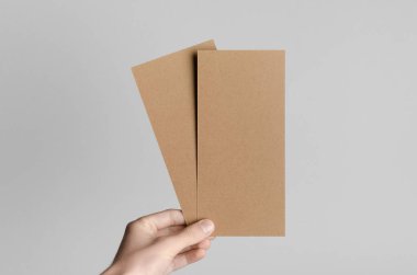 Kraft Dl el ilanı Mock-Up-kraft el ilanları gri bir arka plan üzerinde holding erkek eller.