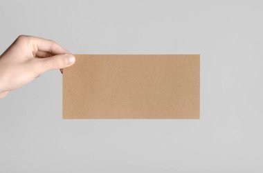 Kraft Dl el ilanı Mock-Up-kraft el ilanı gri bir arka plan üzerinde holding erkek eller.