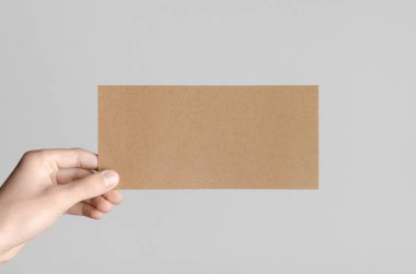 Kraft Dl el ilanı Mock-Up-kraft el ilanı gri bir arka plan üzerinde holding erkek eller.