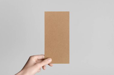 Kraft Dl el ilanı Mock-Up-kraft el ilanı gri bir arka plan üzerinde holding erkek eller.