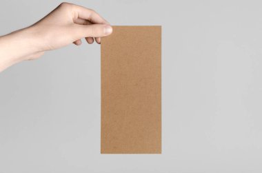 Kraft Dl el ilanı Mock-Up-kraft el ilanı gri bir arka plan üzerinde holding erkek eller.