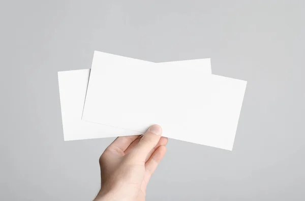 DL el ilanı Mock-Up-erkek elleri boş el ilanları gri bir arka plan üzerinde tutan.