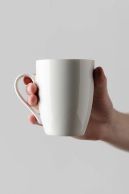 Kupa Mock-Up - erkek bir kupa gri bir arka plan üzerinde tutan eller