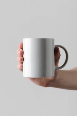 Kupa Mock-Up - erkek bir kupa gri bir arka plan üzerinde tutan eller