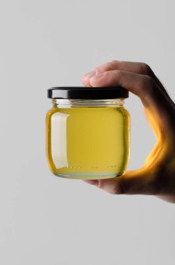 Bal kavanozu Mock-Up-gri bir arka plan üzerine bal kavanozu holding erkek eller