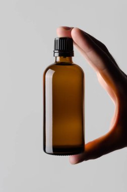 İlaç şişe Mock-Up-gri bir arka plan üzerinde bir ilaç şişesi holding erkek eller