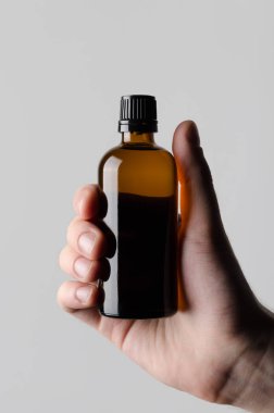 İlaç şişe Mock-Up-gri bir arka plan üzerinde bir ilaç şişesi holding erkek eller