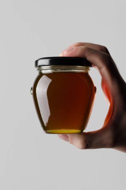 Bal kavanozu Mock-Up-gri bir arka plan üzerine bal kavanozu holding erkek eller