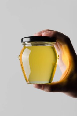 Bal kavanozu Mock-Up-gri bir arka plan üzerine bal kavanozu holding erkek eller