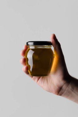 Bal kavanozu Mock-Up-gri bir arka plan üzerine bal kavanozu holding erkek eller