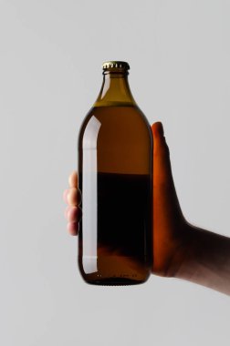 Bira şişe Mock-Up-gri bir arka plan üzerinde bir bira şişesi holding erkek eller