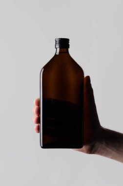 İlaç şişe Mock-Up-gri bir arka plan üzerinde bir ilaç şişesi holding erkek eller